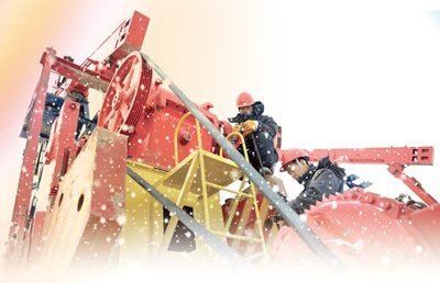石油工人們在風雪中安裝抽油機。